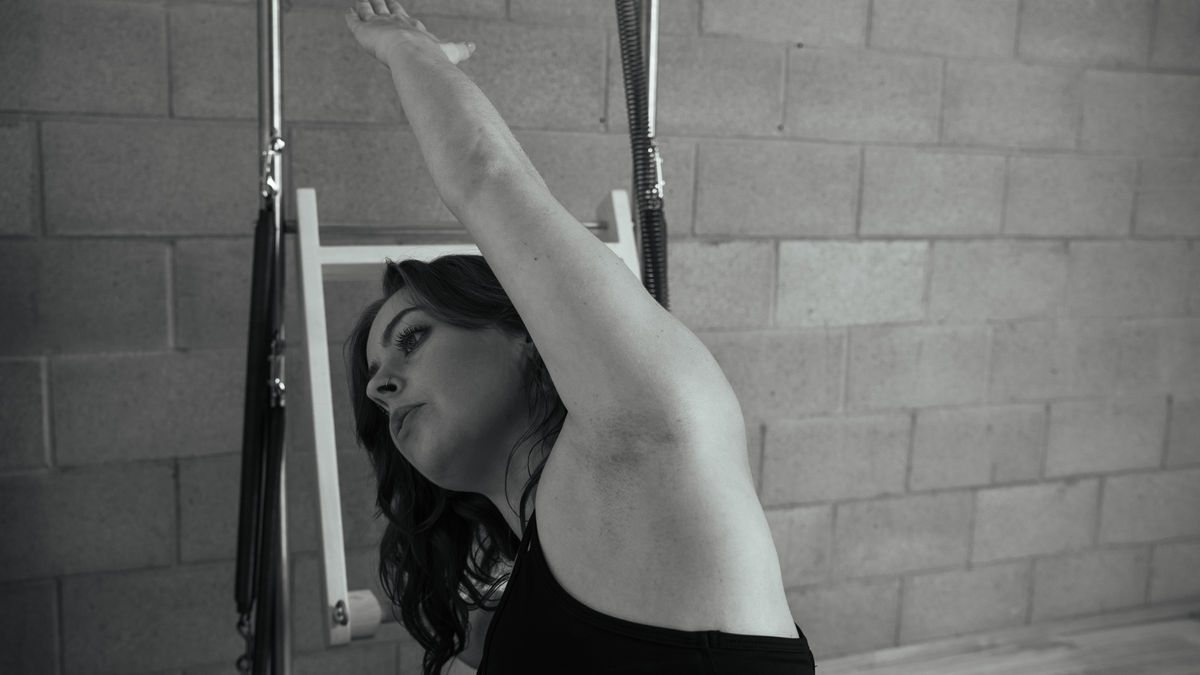 Focused woman, Jaime Elkayam, practicing exercises at the best Pilates studio in West Hollywood, skillfully using a Contrology tower for a balanced workout, representing the high-quality training provided at our LA Pilates studio.