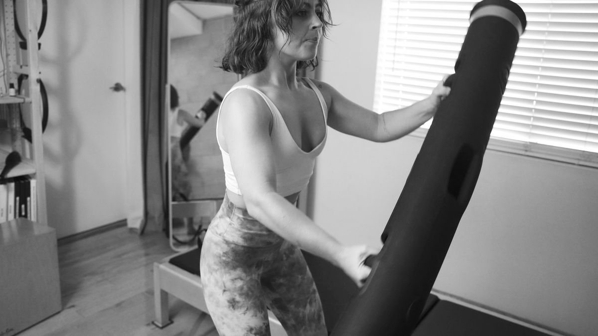 Enhancing functional movement: a determined woman skillfully incorporating a Vipr into her Pilates routine at our premier West Hollywood Pilates studio.