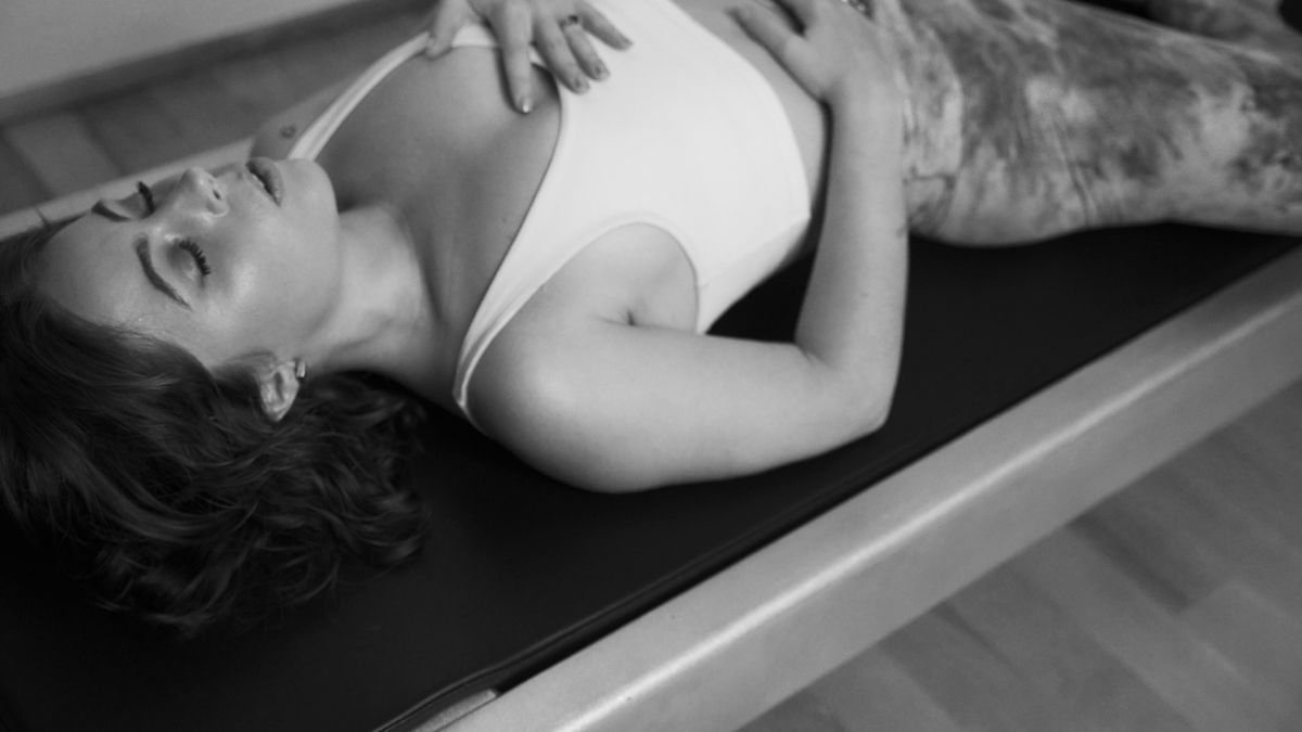 Accomplished Pilates enthusiast relaxing into the comfort of the Contrology tower at the best Pilates West Hollywood studio.