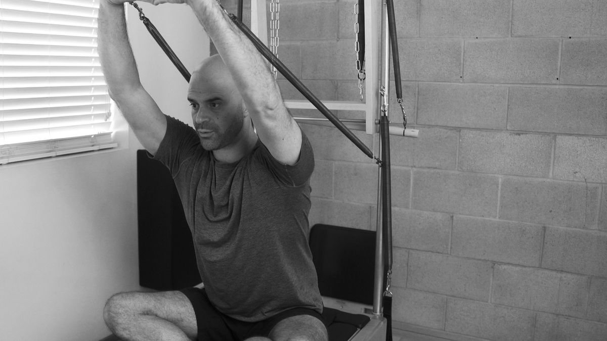 Unlock your body's potential at our Pilates studio in Los Angeles, man performing a challenging exercise know as "shaving" on a Contrology tower.