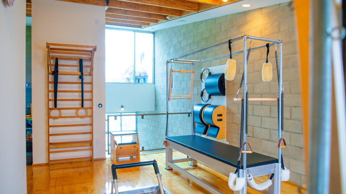 Vintage classical Contrology Pilates studio with a Cadillac trapeze table and reformer, private one-on-one Pilates in West Hollywood